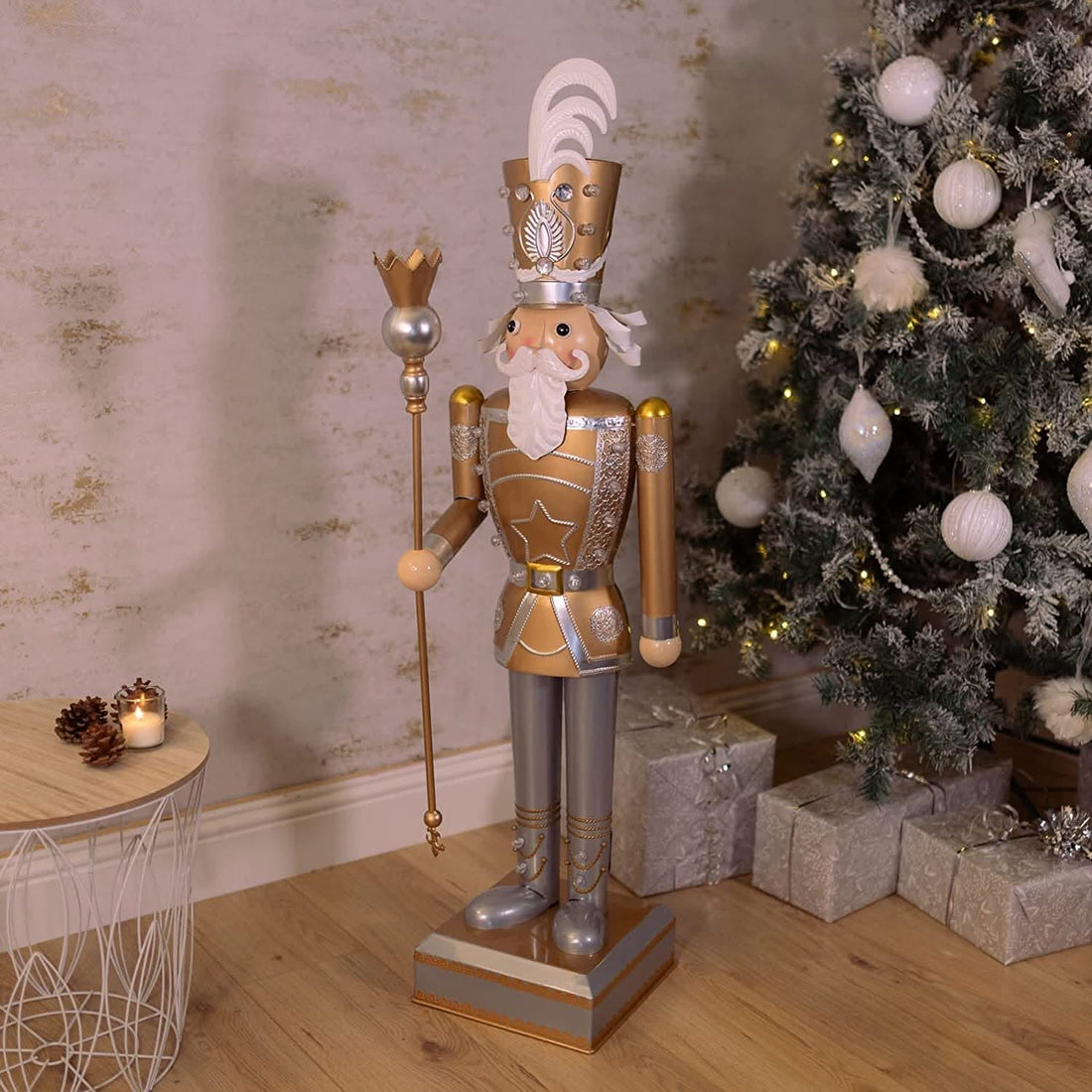 Gold and Silver nutcracker placed next to a Christmas tree and some presents
