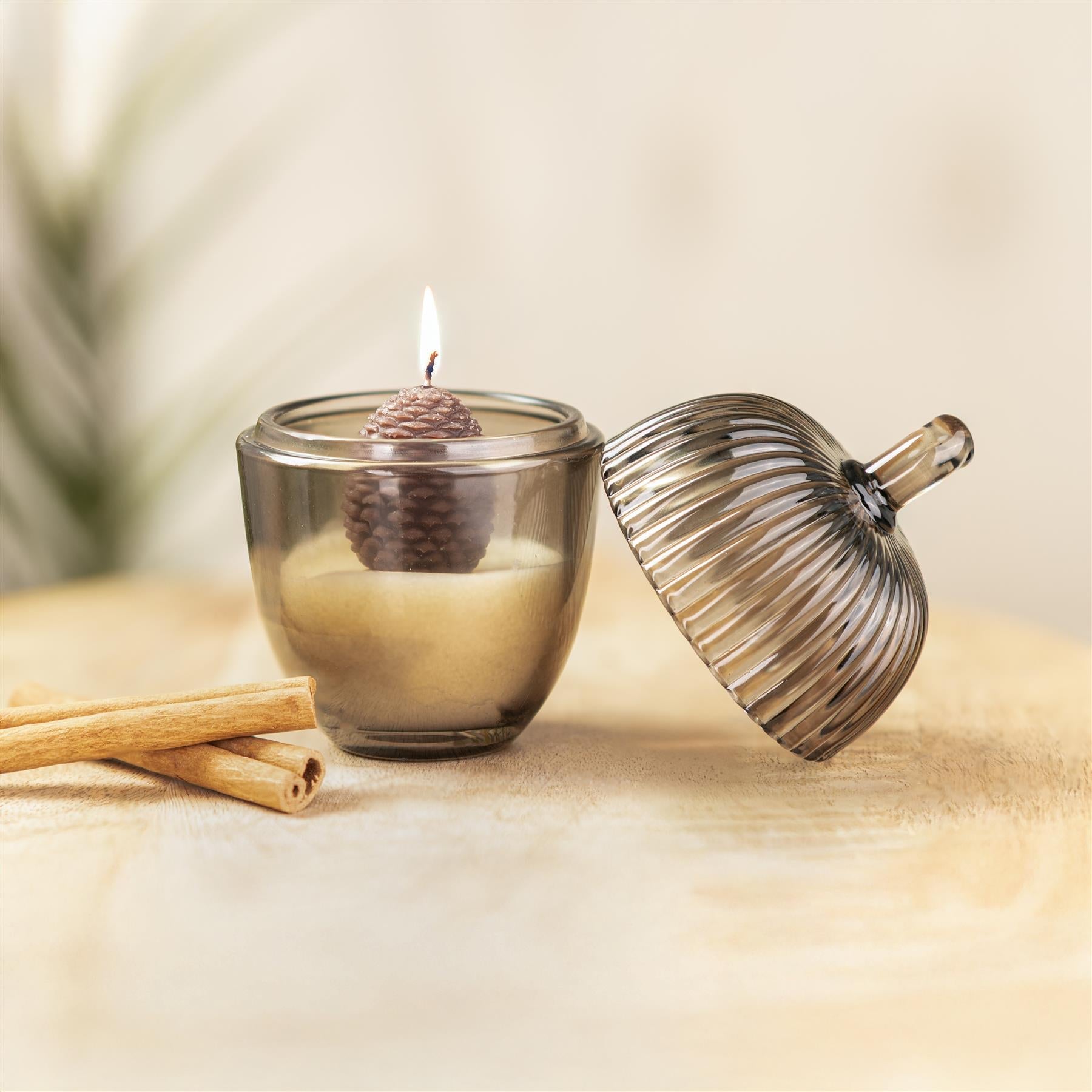 Acorn shaped grey glass candle with wax acron inside.