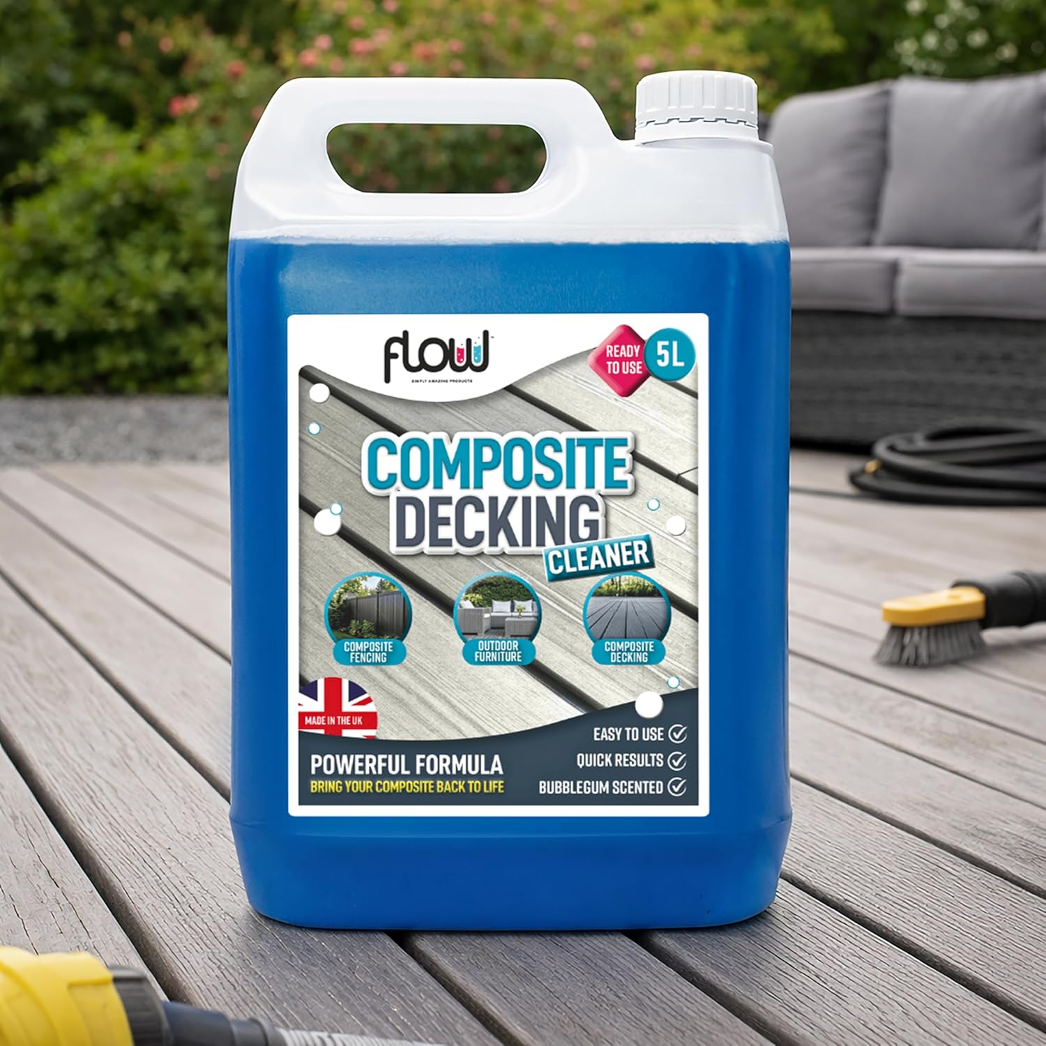 Bottle of blue liquid in a clear carton with ' composite decking' labels over horizontally on bottle. On top of garden decking area in garden 