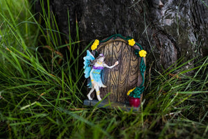 Miniature fairy doors displayed at the base of a tree