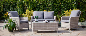 Outdoor furniture set with wicker chairs and a coffee table on a patio.