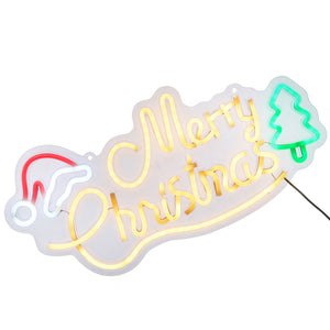 A Christmas-themed LED neon sign with 'Merry Christmas' in glowing yellow script, a red and white Santa hat on the left, and a green Christmas tree on the right, set against a plain white background.