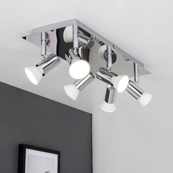 Modern ceiling light fixture with four white bulbs on a gray wall background
