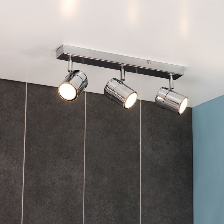 Modern ceiling light fixture with three spotlights on a neutral background