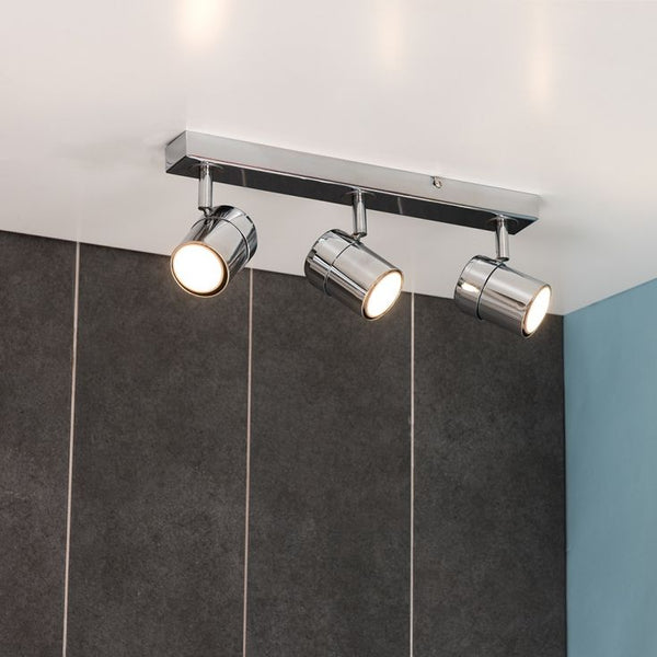 Modern ceiling light fixture with three spotlights on a neutral background