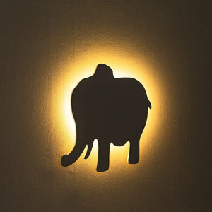Wall light fixture with an elephant silhouette on a dark background