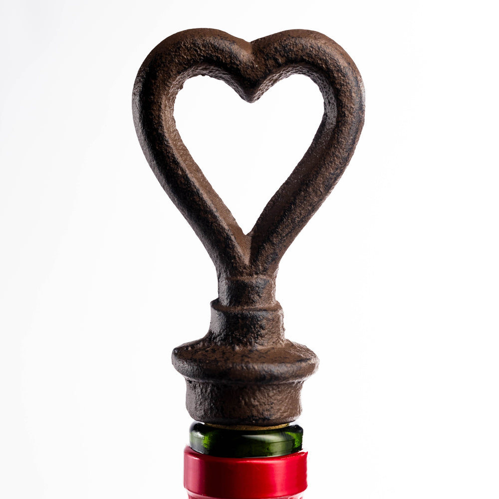 Wine bottle with a heart-shaped bottle opener against a warm background