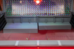 Model of a train station platform with a colorful curtain in the background