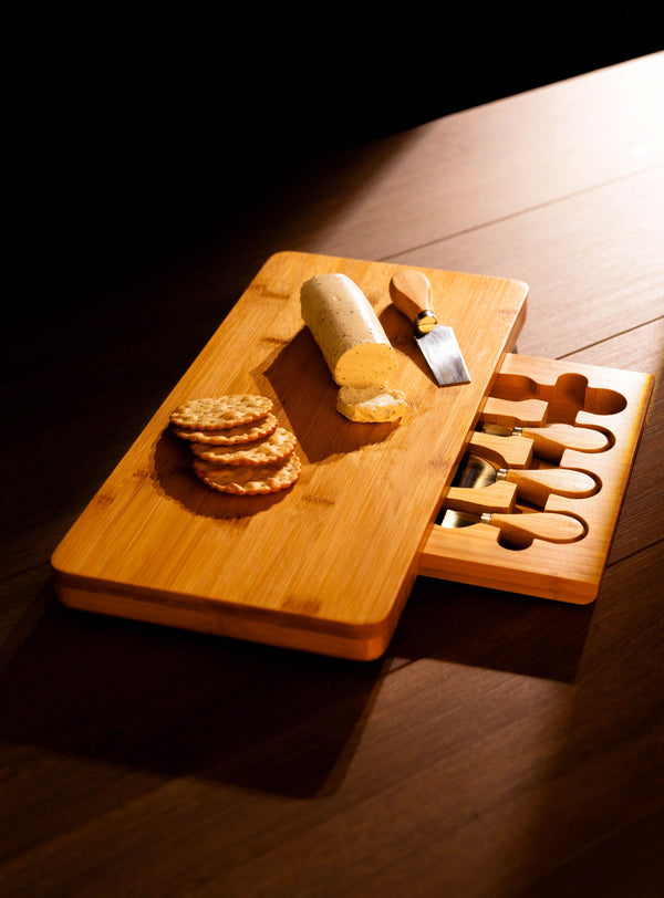 Wooden cutting board with cheese and crackers on a wooden surface