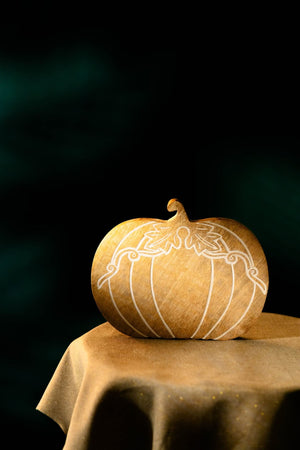 Decorative pumpkin with intricate carvings on a dark background