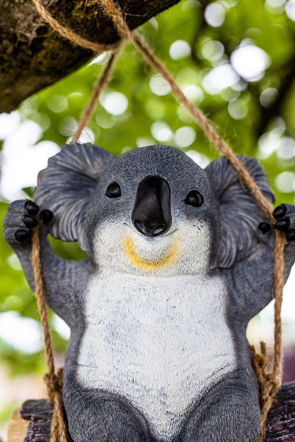 Resin koala bear swinging from tree