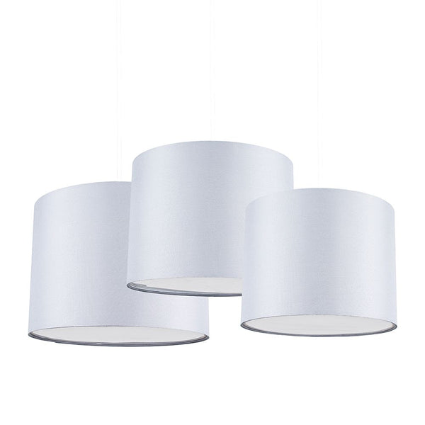 Three white cylindrical lampshades on a white background