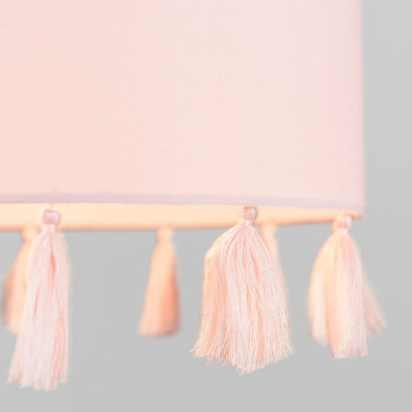 Pink lampshade with tassels on a gray background