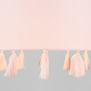 Pink tassel garland on a light pink and gray gradient background
