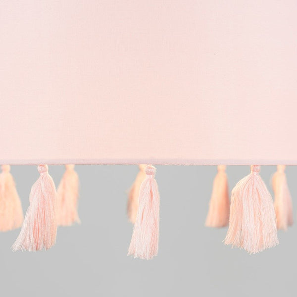 Pink tassel garland on a light pink and gray gradient background