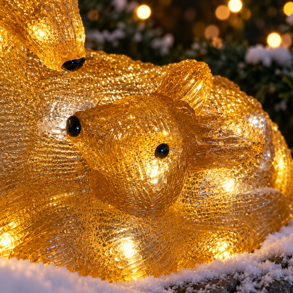 A close up of a golden glowing deer and baby deer figurine with warm white LED lights