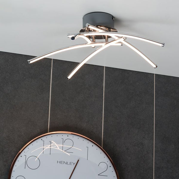 Modern ceiling light fixture with a clock below on a gray wall.