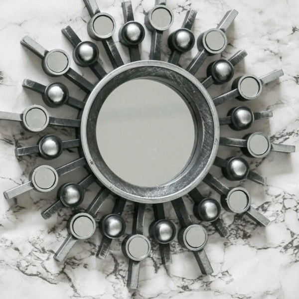 Silver sunburst mirror set shown on feature wall