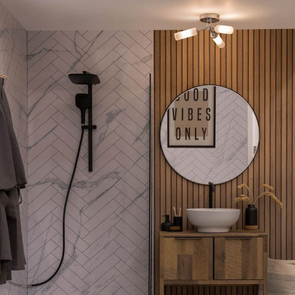 Bathroom interior with shower setup, round mirror, and wooden vanity.
