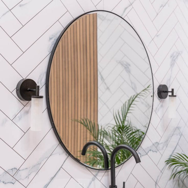 Round mirror with wooden half-circle design on a marble wall