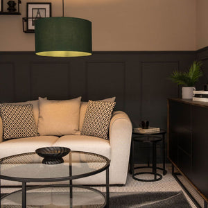 Modern living room with a beige sofa, decorative pillows, and a green lamp.