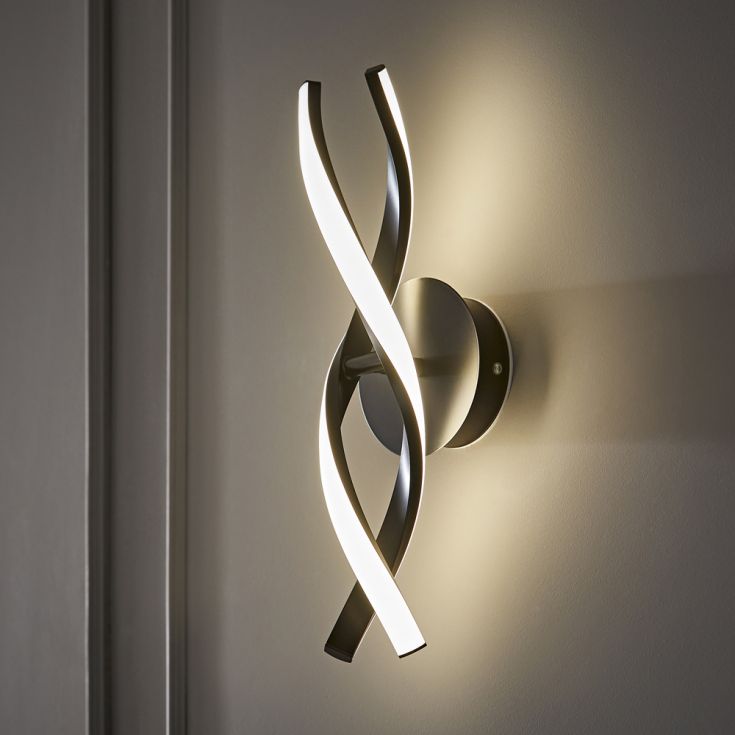Modern wall sconce with curved design on a neutral wall