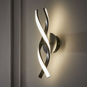 Modern wall sconce with curved design on a neutral wall