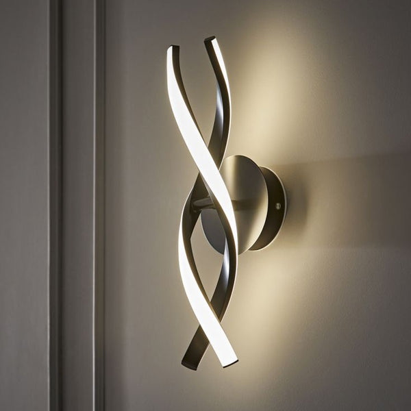 Modern wall sconce with curved design on a neutral wall