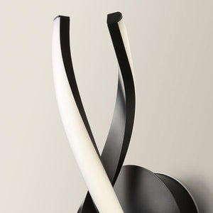 Modern wall light fixture with black and white design on a neutral background