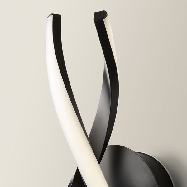 Modern wall light fixture with black and white design on a neutral background