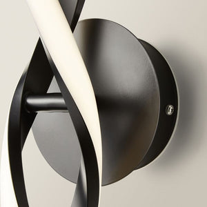 Modern wall light fixture with black and white design on a neutral background