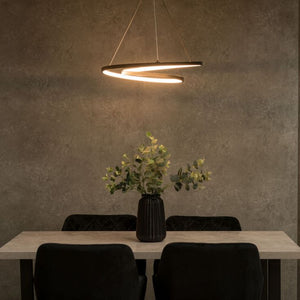 Modern dining area with a pendant light, table, chairs, and a vase with plants on a textured wall background.