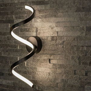 Modern wall-mounted light fixture with a wavy design on a stone wall background