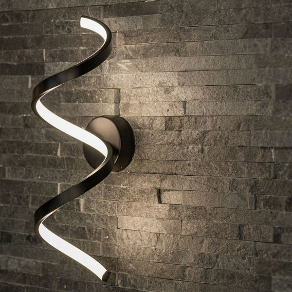 Modern wall-mounted light fixture with a wavy design on a stone wall background