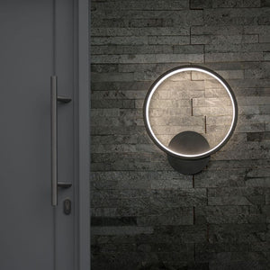 Round wall-mounted light fixture on a textured stone wall