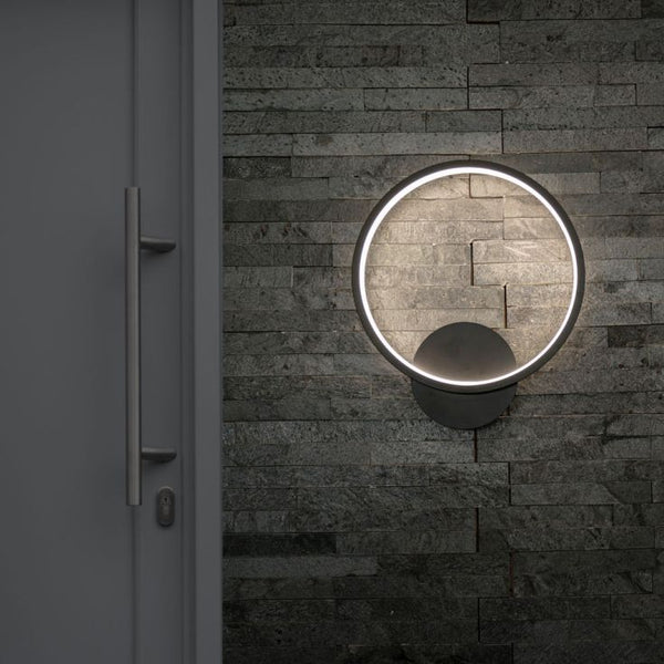 Round wall-mounted light fixture on a textured stone wall