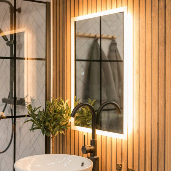 Bathroom with illuminated mirror, sink, and plant