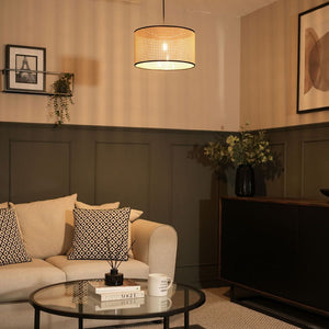 Living room with beige sofa, decorative pillows, and a coffee table with a lamp and books.