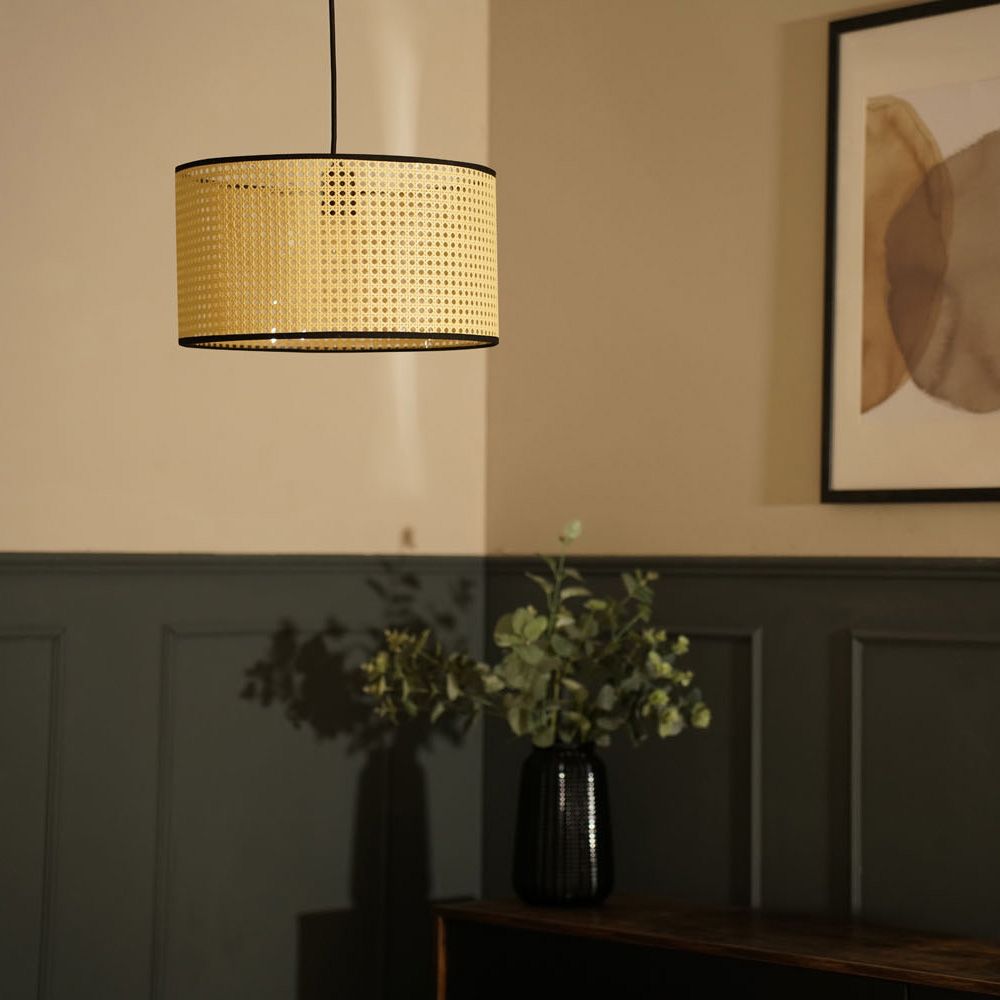 Decorative pendant light with woven shade in a room setting.