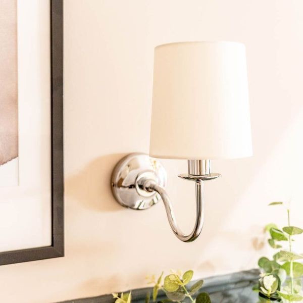 Wall-mounted lamp with a white shade in a room setting