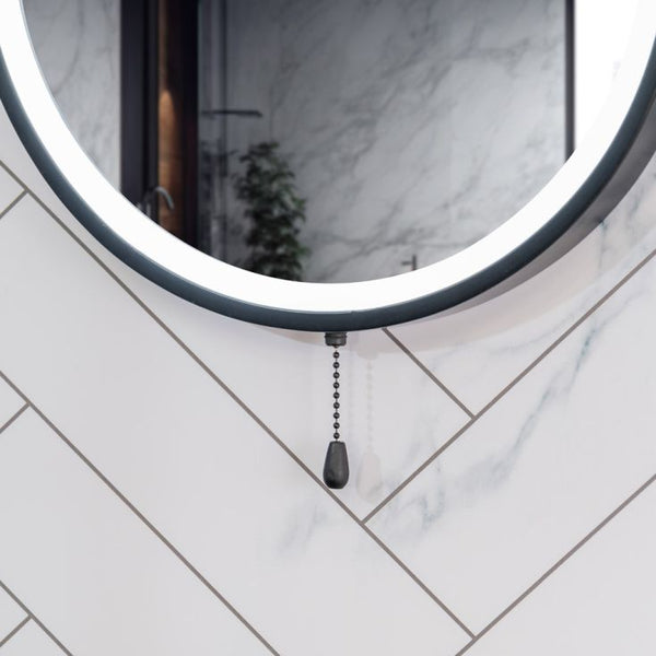 Round mirror with a pull chain on a tiled wall