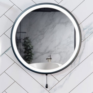 Round wall mirror with black frame on a tiled bathroom wall
