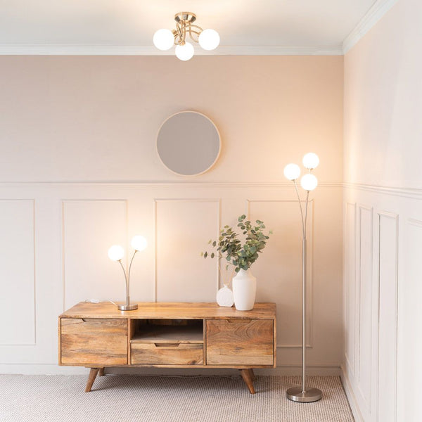 Modern living room with wooden TV stand, decorative items, and wall lights.