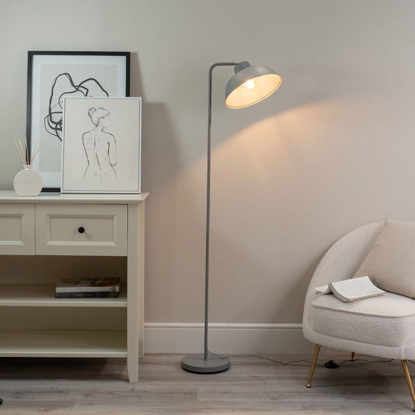 Modern living room with a floor lamp, armchair, and wall art.