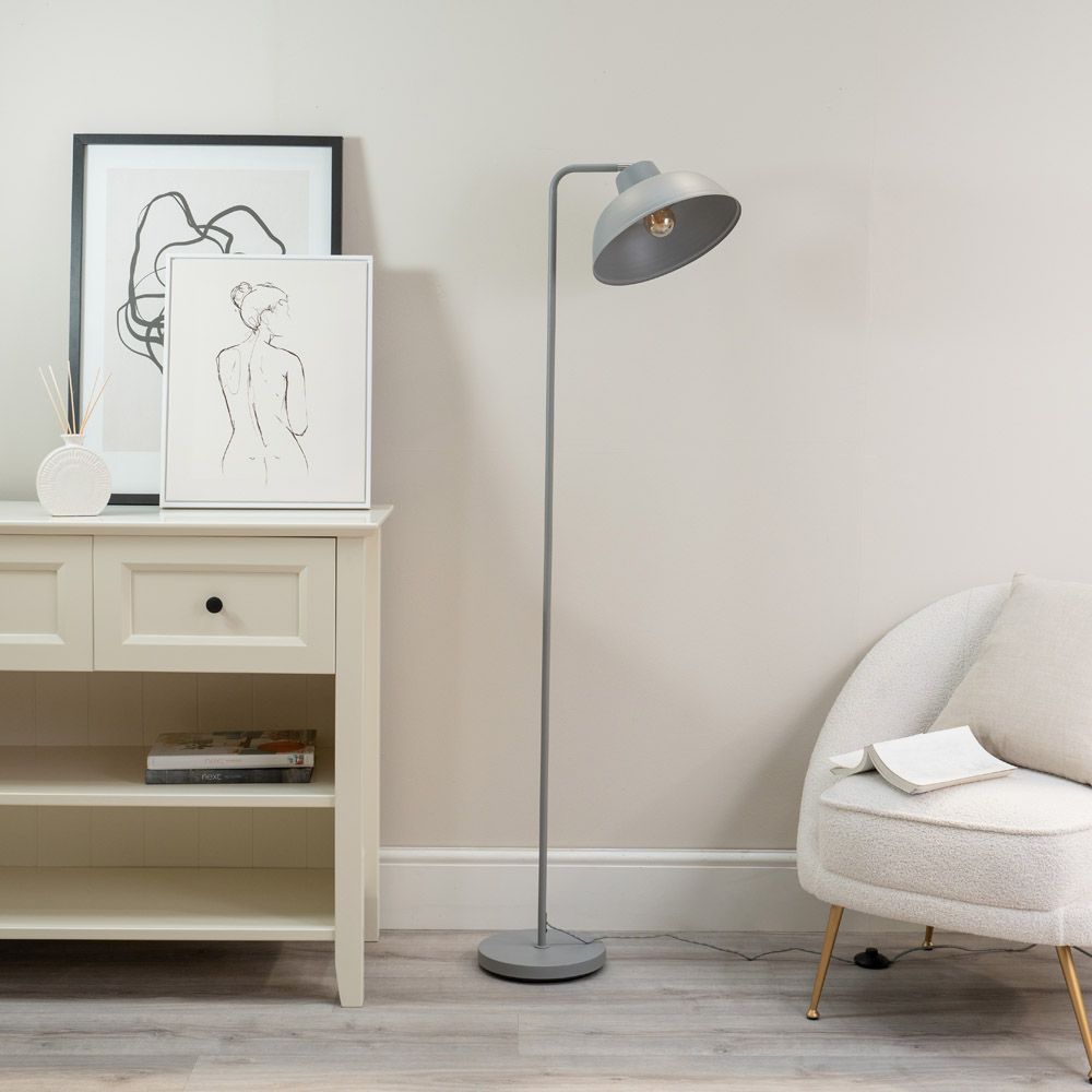 Modern interior with a floor lamp, white cabinet, and armchair.