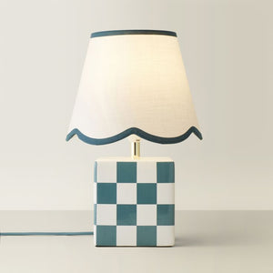 Table lamp with checkered base and wavy edge on a plain background