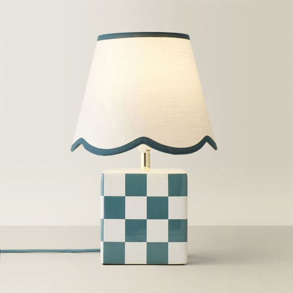 Table lamp with checkered base and wavy edge on a plain background