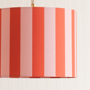 Striped lampshade with red and pink vertical stripes on a white background