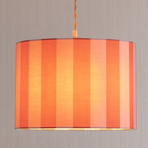 Striped lampshade with orange and red vertical stripes on a plain background