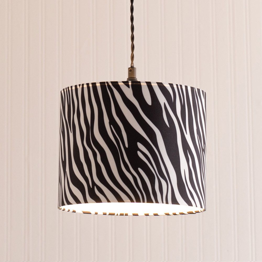 Lamp with zebra pattern shade on a striped wall background